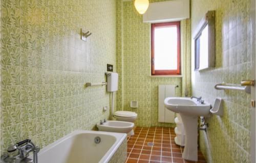 y baño con 2 aseos, bañera y lavamanos. en Villa Delia, en Stalettì