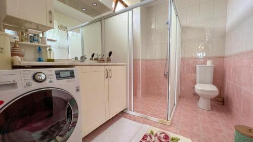 a bathroom with a washing machine and a toilet at Heaven Garden Villa in Trabzon