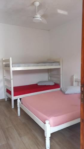 Hostel Mar da Vila في برايا جراندي: غرفة نوم مع سرير بطابقين مع مرتبة وردية