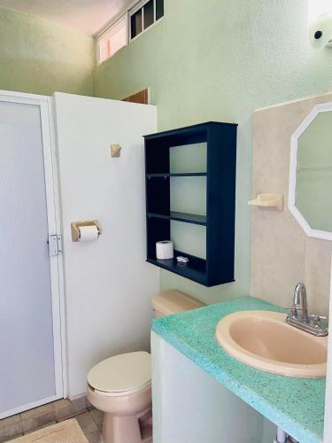 a bathroom with a toilet and a sink at Los Angeles en el Paraiso in San Patricio Melaque