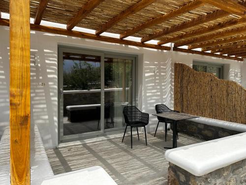 een patio met een tafel en stoelen erop bij Abelos Mykonos in Mykonos-stad
