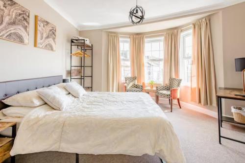 a bedroom with a large white bed and a chair at No 58 in Great Yarmouth