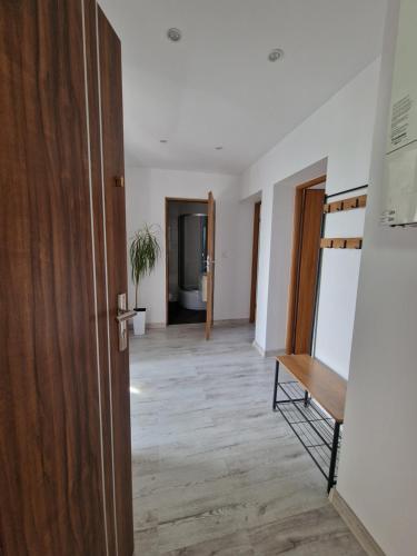 - un couloir avec une porte et du parquet dans l'établissement Przytulny apartament + siłownia, à Bytom