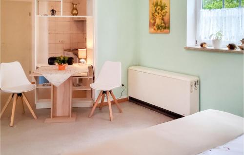 una cucina con 2 sedie bianche, un tavolo e un frigorifero di Cozy Apartment In Bad Schandau- Kleing, With Wifi a Kleingießhübel