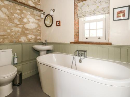 y baño con bañera, aseo y lavamanos. en Rose Cottage en Dorchester