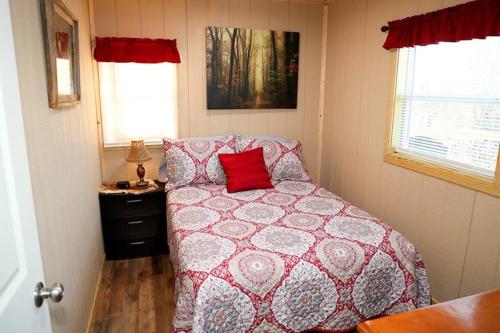 a bedroom with a bed with a red pillow on it at Private Hot tub-Lakefront-Deer Lodge in Commerce