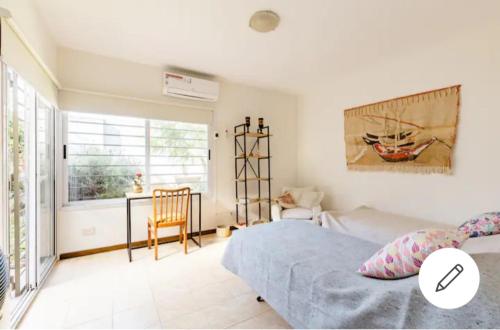 a bedroom with a bed and a table and a window at Habitación con baño privado Regis Haus in Villa Adelina