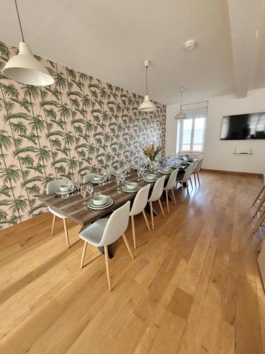 une grande salle à manger avec une longue table et des chaises dans l'établissement Grand gîte citadin avec SPA, billard, babyfoot, à Villedieu-les-Poêles