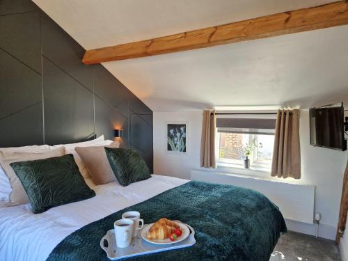 a bedroom with a bed with a tray of food on it at Wesley Chapel- Cyanacottages in Whitby