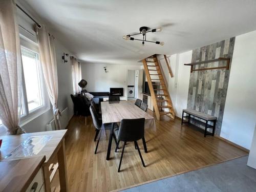 un salon avec une table et des chaises et un escalier dans l'établissement Appartement étoilé duplex tout confort, à Gérardmer