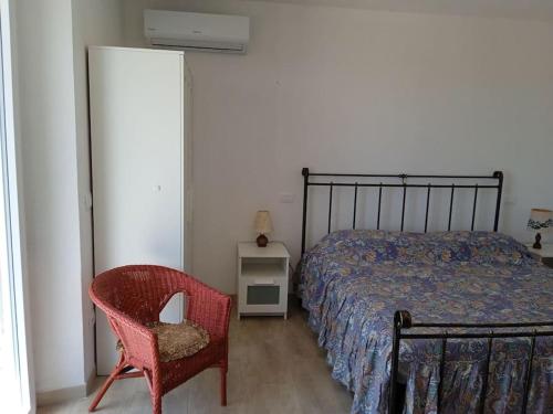 1 dormitorio con 1 cama y 1 silla roja en Casa vacanze in pietra Il Nibbio Reale, en Semproniano