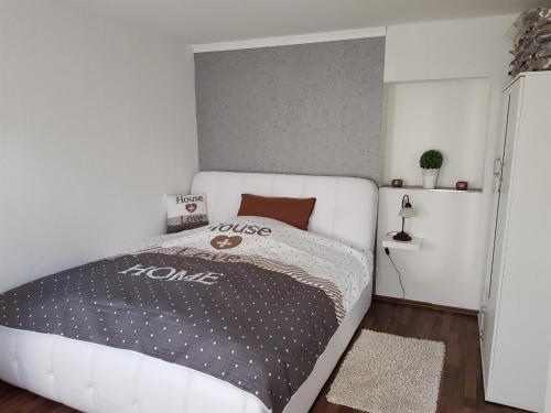 a bedroom with a white bed with a black comforter at Ferienwohnung Conny in Winsen