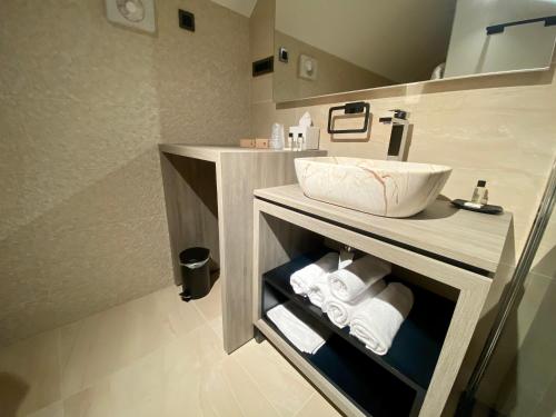 a bathroom with a sink and towels on a shelf at Boutique hotel ZBILJE in Zbilje