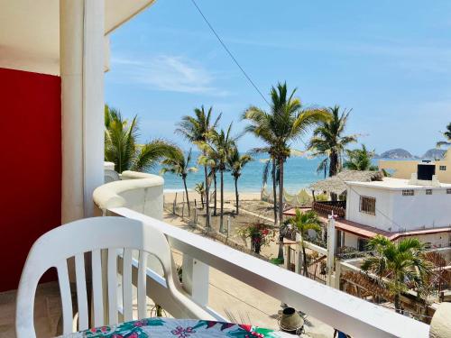 a balcony with a view of the beach and palm trees at Los Angeles en el Paraiso in San Patricio Melaque