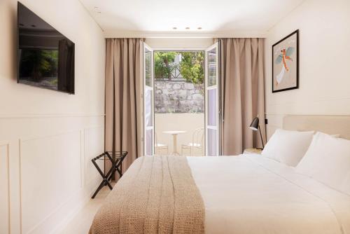 um quarto de hotel com uma cama e uma janela em Doryssa Theorem Hotel em Pythagoreio