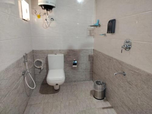 a bathroom with a toilet and a shower at Nature's Deck - River Side Cabana's in Kārwār