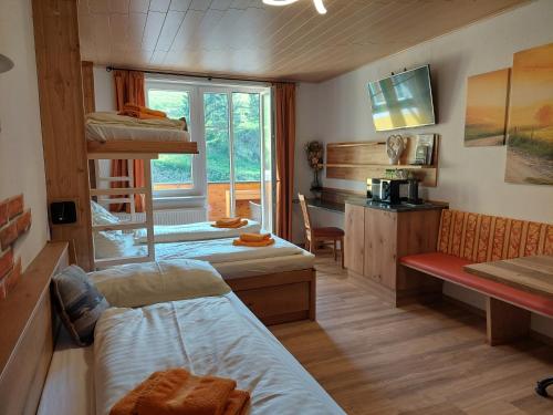 a room with two bunk beds and a desk and a room with a desk at Gasthof Klug zum Ehrensepp in Modriach