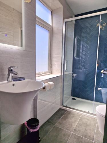 a bathroom with a sink and a shower at Wesley Chapel- Cyanacottages in Whitby