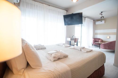 a bedroom with a large bed with towels on it at John's Hotel in Chalkida