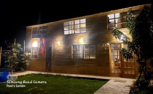 un edificio in legno con una bandiera sopra la notte di Casa de Campo Villa Angélica Lunahuaná a Lunahuaná