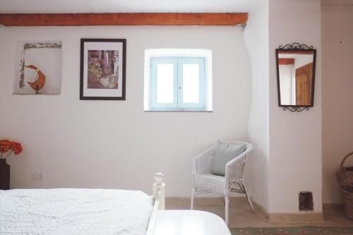 sypialnia z białym łóżkiem i krzesłem w obiekcie Soca Valley Berghaus w mieście Kobarid