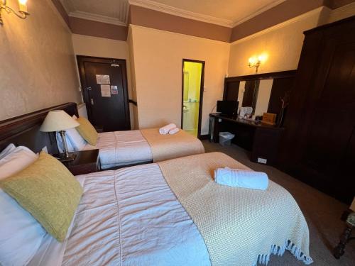 a hotel room with two beds and a desk at Georgian House Hotel in Derby