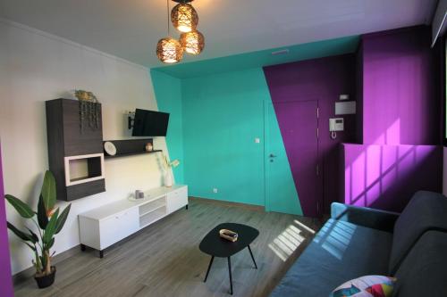 a living room with a blue and purple wall at CASATURIS NEWON APARTAMENTOS en EL CAMPELLO in El Campello