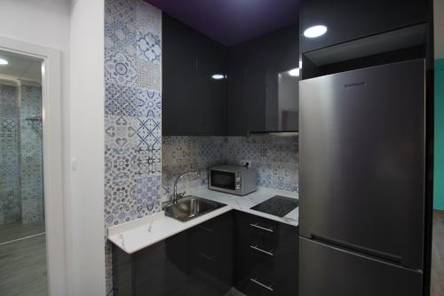 a kitchen with a sink and a refrigerator at CASATURIS NEWON APARTAMENTOS en EL CAMPELLO in El Campello