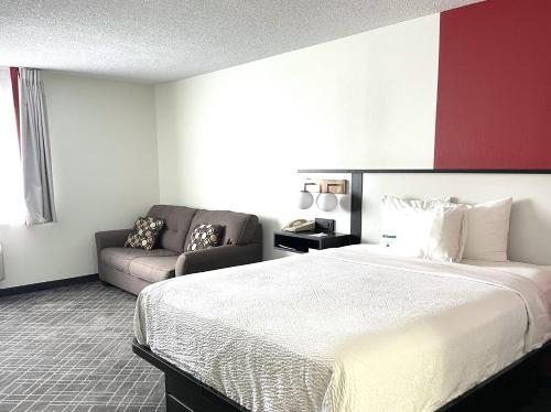 a hotel room with a large bed and a couch at Ramada by Wyndham Waupaca in Waupaca