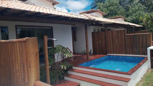 uma casa com uma piscina e uma cerca de madeira em Casa 2 Suítes com Ar, Piscina a 400 mts Praia - Taipu de Fora Barra Grande #3 em Maraú