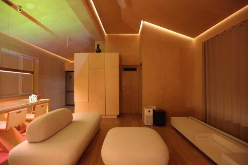 ein Wohnzimmer mit einem weißen Sofa und einer Küche in der Unterkunft Entire apartment or single rooms in Homegarden Park near Camp Humprehys in Pyeongtaek