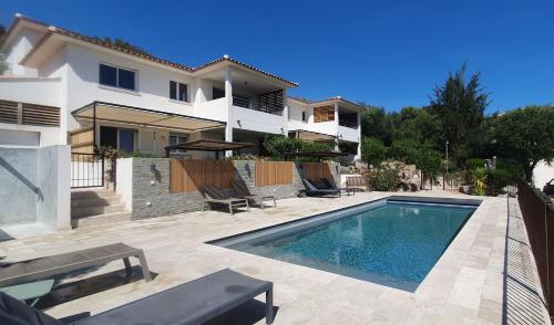 une villa avec piscine devant une maison dans l'établissement Très belle Résidence vue mer et piscine chauffée - BACCALOCATION, à Porto-Vecchio