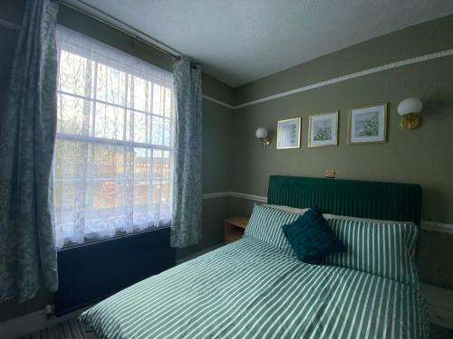1 dormitorio con cama y ventana en The Old Surgery Room Only, en Scarborough