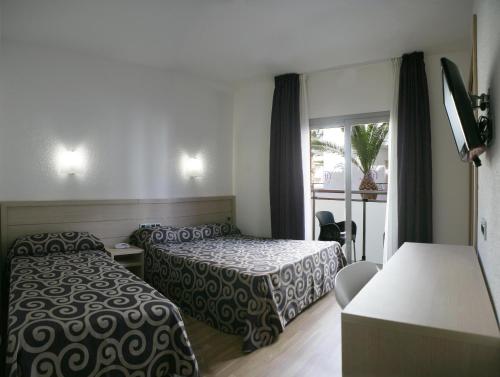 a hotel room with two beds and a window at Tossa Beach Center in Tossa de Mar