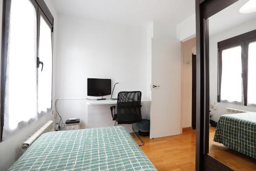 a bedroom with two beds and a desk and a chair at Vivienda Turística Lore Artian. in Laguardia