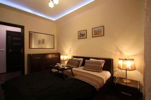 a bedroom with a bed with two lamps and a table at Central Apartments Sz7-66 in Gdańsk