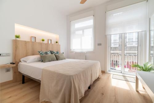 ein weißes Schlafzimmer mit einem großen Bett und einem Fenster in der Unterkunft Casa junto al Mar in Vigo