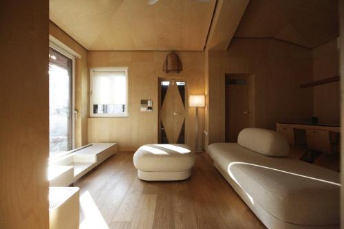 a bedroom with a bed and a bench and a window at Entire apartment or single rooms in Homegarden Park near Camp Humprehys in Pyeongtaek