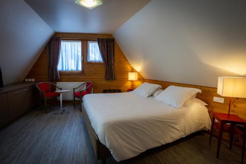 a hotel room with a bed and a table and chairs at Logis Hôtel de la Tour in Ribeauvillé