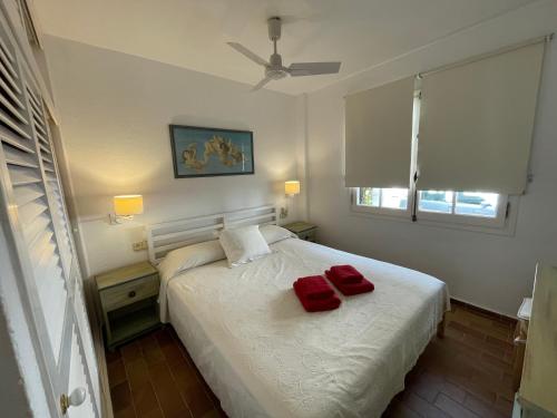 um quarto com uma cama com duas almofadas vermelhas em ES CASTELL 1 6 by SOM Menorca em Fornells