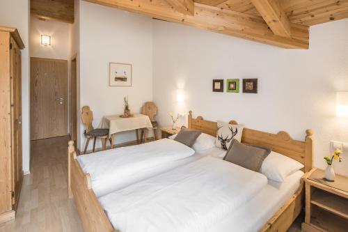 two beds in a room with a table and a table at Residence Lärchwiese in San Giacomo
