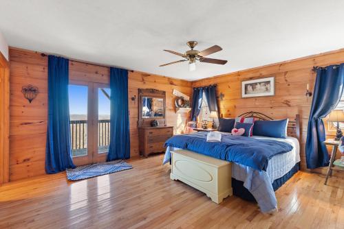 Un dormitorio con una cama y un ventilador de techo. en Cupids Retreat, en Boone