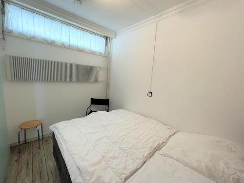 um quarto branco com uma cama e uma janela em Ferienpark Sierksdorf App 413 - Strandlage em Sierksdorf