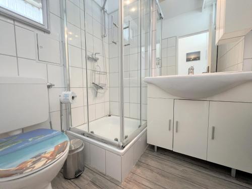 uma casa de banho com um chuveiro, um WC e um lavatório. em Ferienpark Sierksdorf App 413 - Strandlage em Sierksdorf