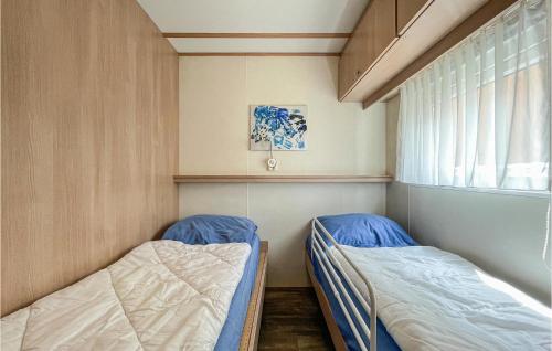 twee bedden in een kleine kamer met een raam bij 2 Bedroom Amazing stacaravan In Epe in Epe