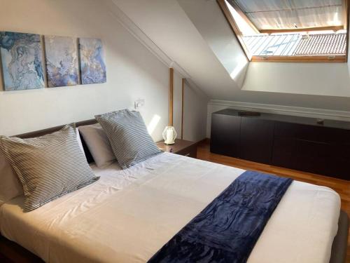 a bedroom with a large bed with a skylight at HyP - El Nido de Iría in Poio