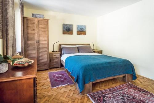 a bedroom with a bed with a blue blanket and a table at Apartma Maja in Kobarid