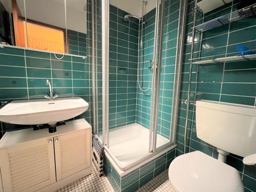 La salle de bains est pourvue d'un lavabo, d'une douche et de toilettes. dans l'établissement Ferienpark Sierksdorf App 382 - Strandlage, à Sierksdorf