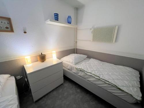 - une chambre avec un lit et une table de nuit éclairée dans l'établissement Ferienpark Sierksdorf App 382 - Strandlage, à Sierksdorf