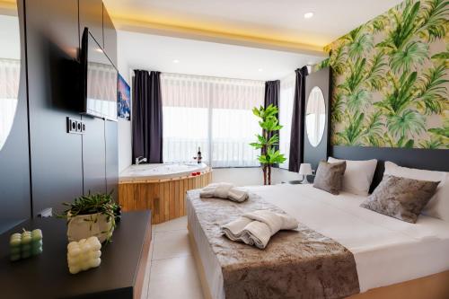 a bedroom with a large white bed and a tub at Mrt Suites Lara in Antalya